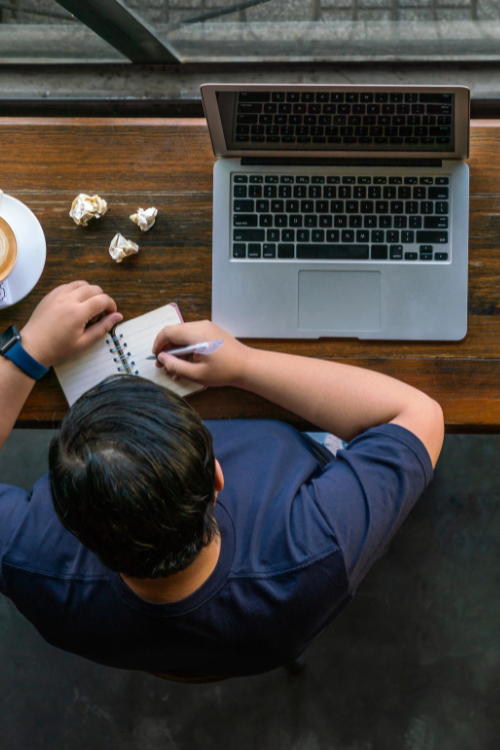 Content marketing manager writing notes on paper.